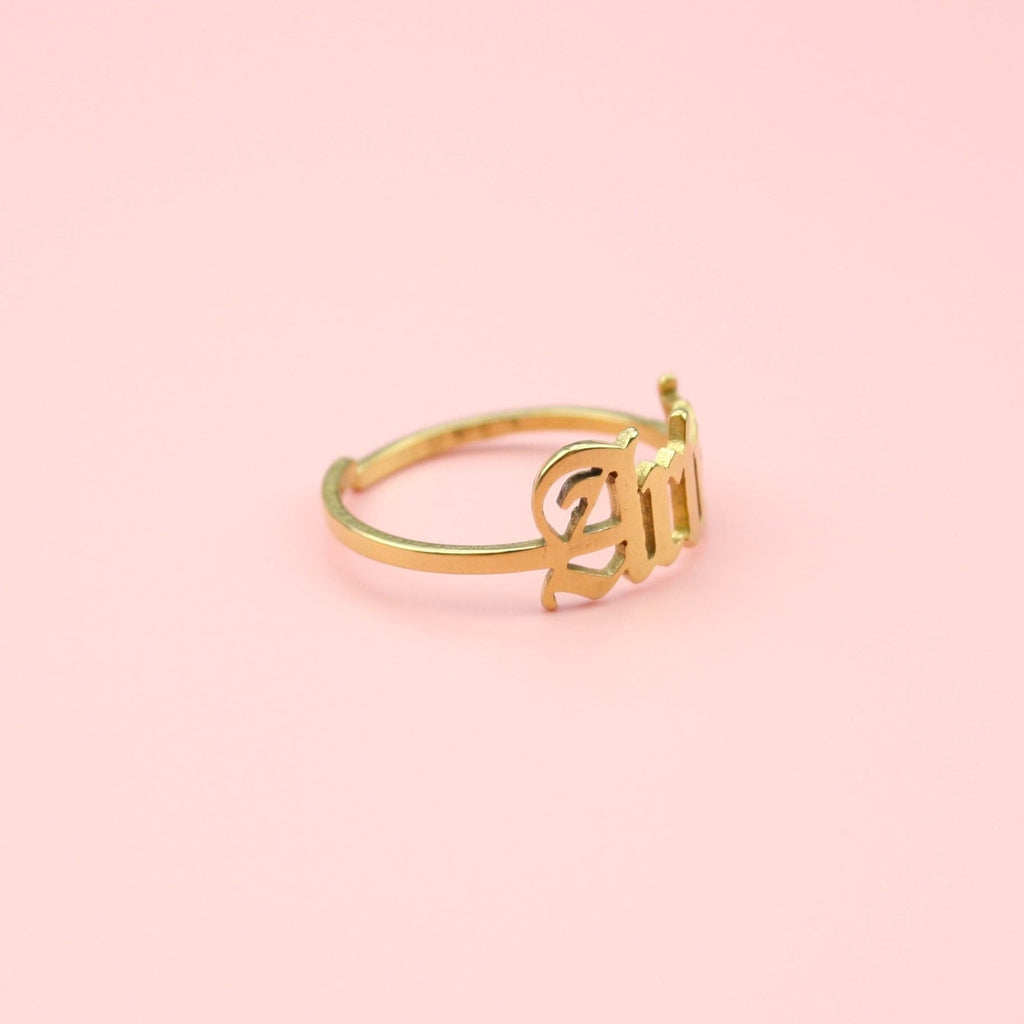 Gold plated stainless steel ring with 'Aries' written in an old english font