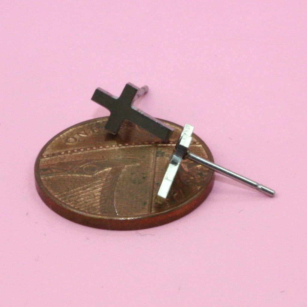 Cross Studs lying on a penny