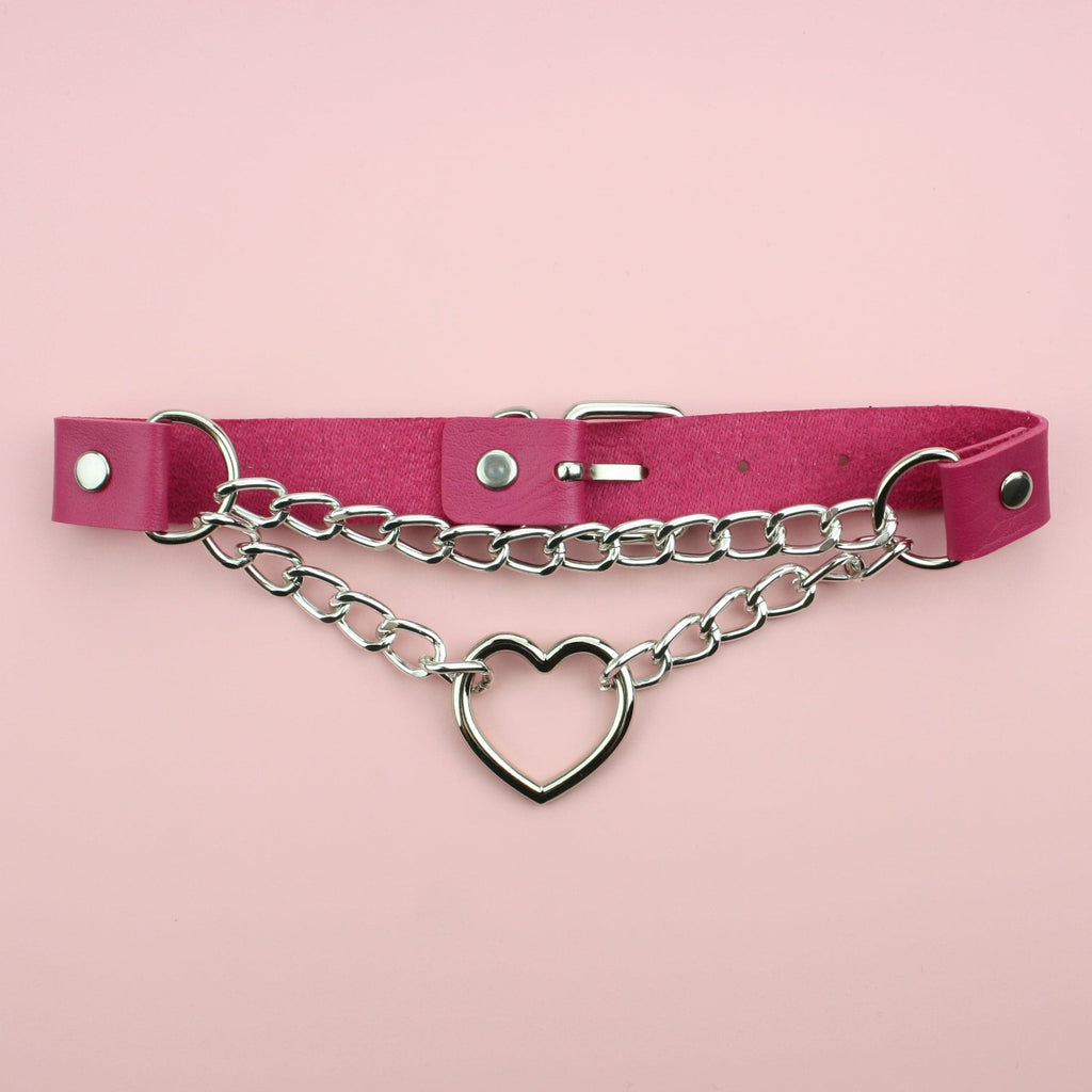Pink faux leather strap featuring a thick double chain with a cut out heart in the middle