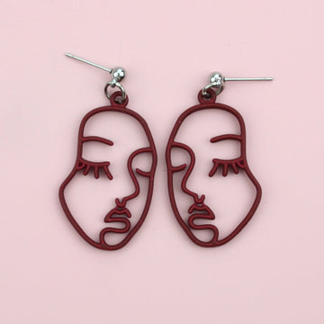 Burgundy cut out abstract face earrings on stainless steel studs