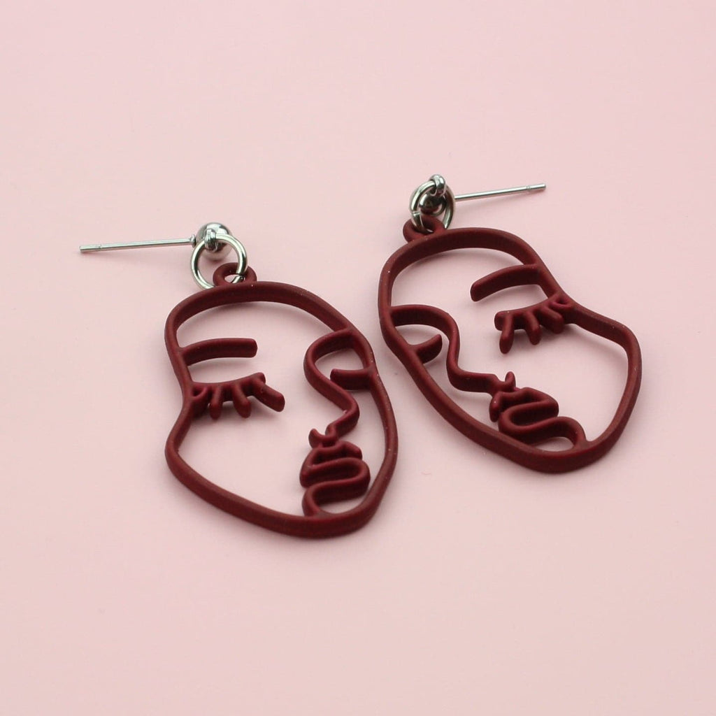 Burgundy cut out abstract face earrings on stainless steel studs