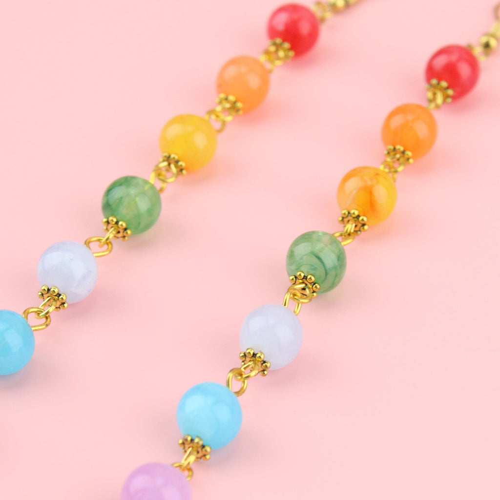 Rainbow coloured beads on gold plated charms with gold plated stainless steel earwires