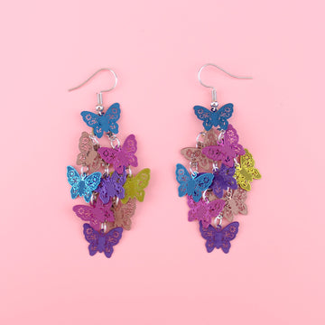 A cluster of blue, rose gold, pink, purple and gold butterfly charms on stainless steel earwires