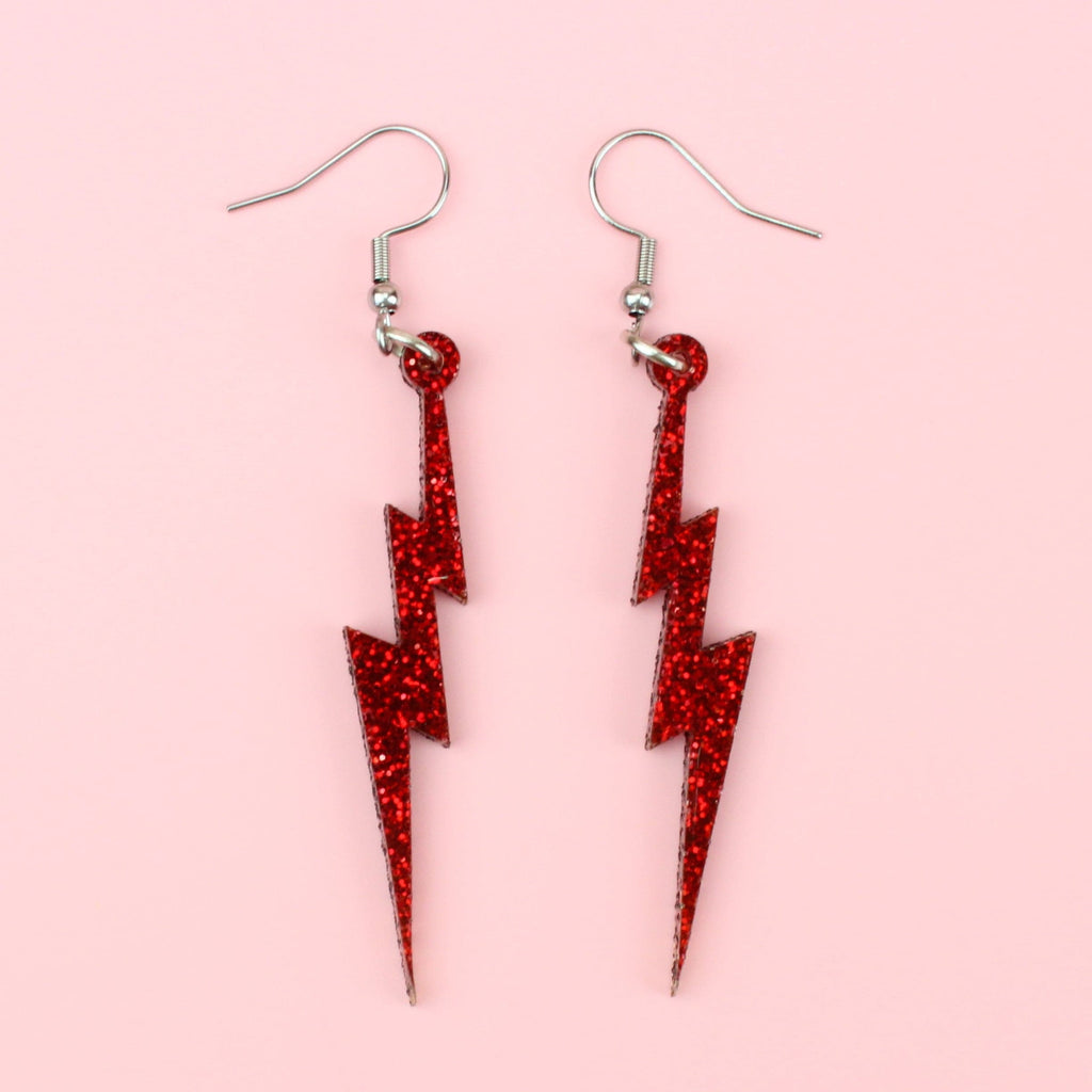 Laser cut red glitter perspex earrings with a lightning bolt design on stainless steel earwires