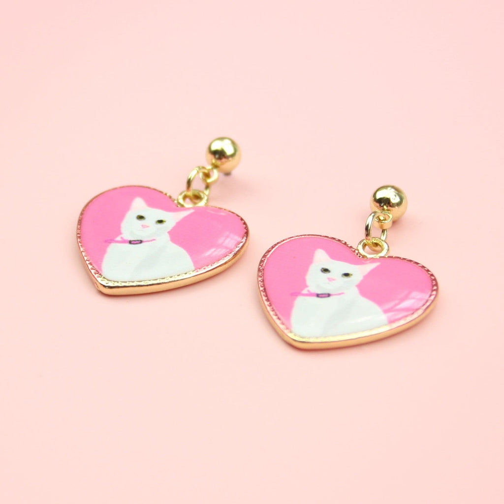 Gold plated stainless steel studs with pink heart charms featuring a portrait of a white cat