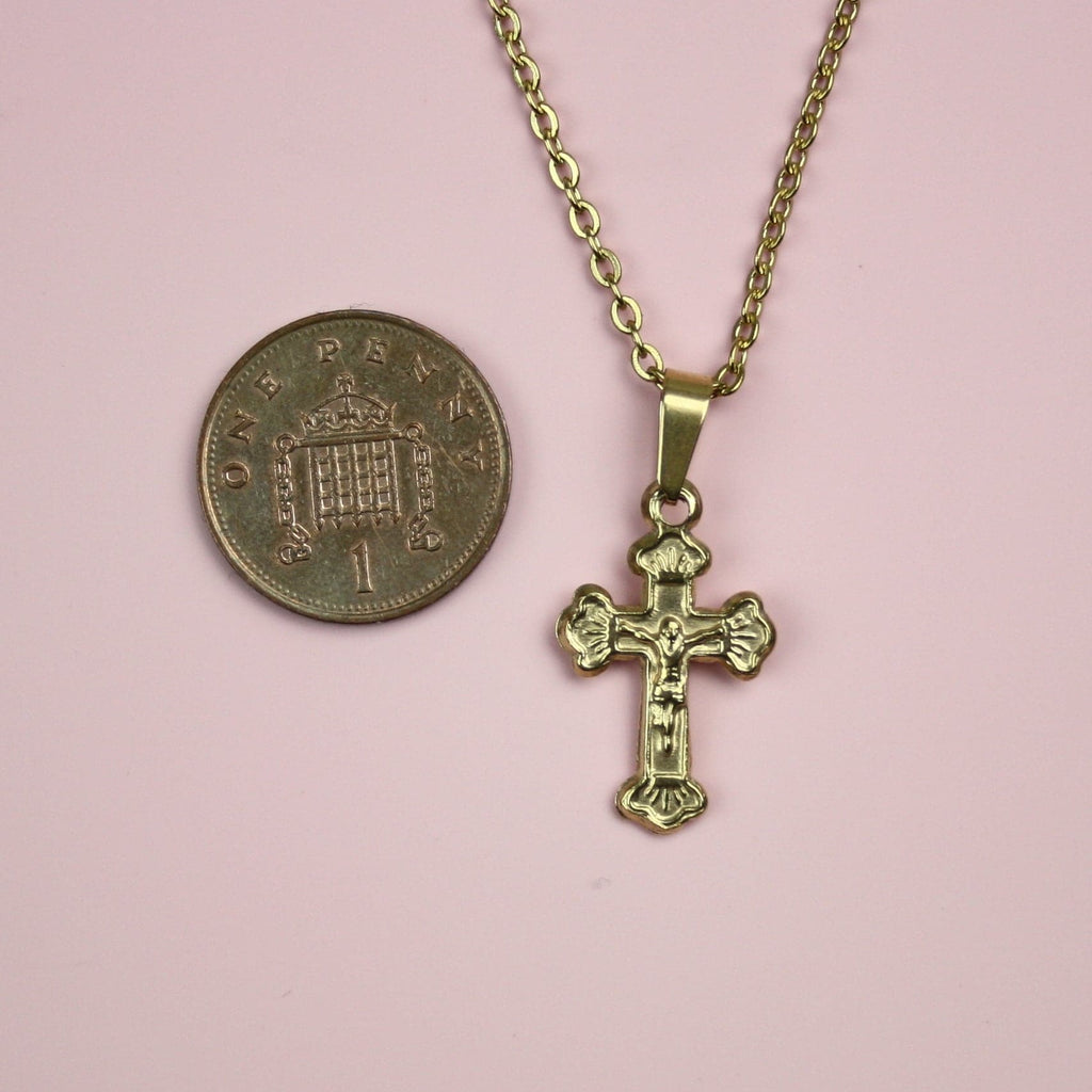 Gold Plated Stainless Steel necklace with crucifix pendant showing a penny next to it for scale