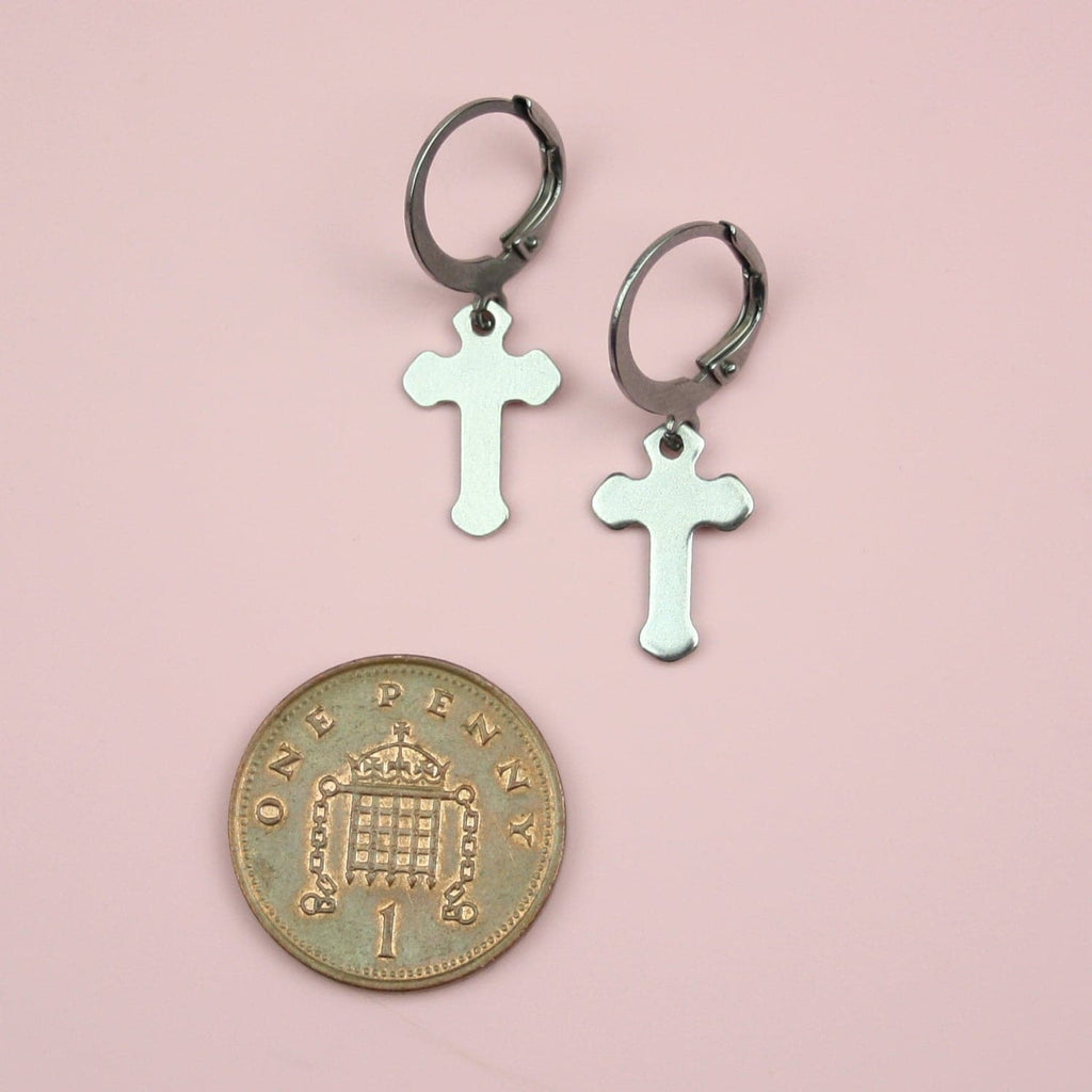 Stainless Steel hoops featurin a gothic cross charm with a penny next to it for scale