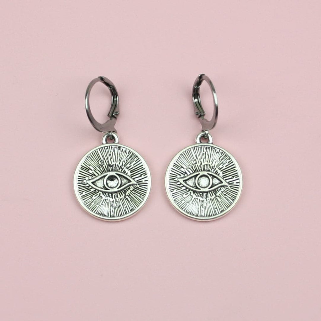 Stainless steel hoop earrings featuring silver plated evil eye charms