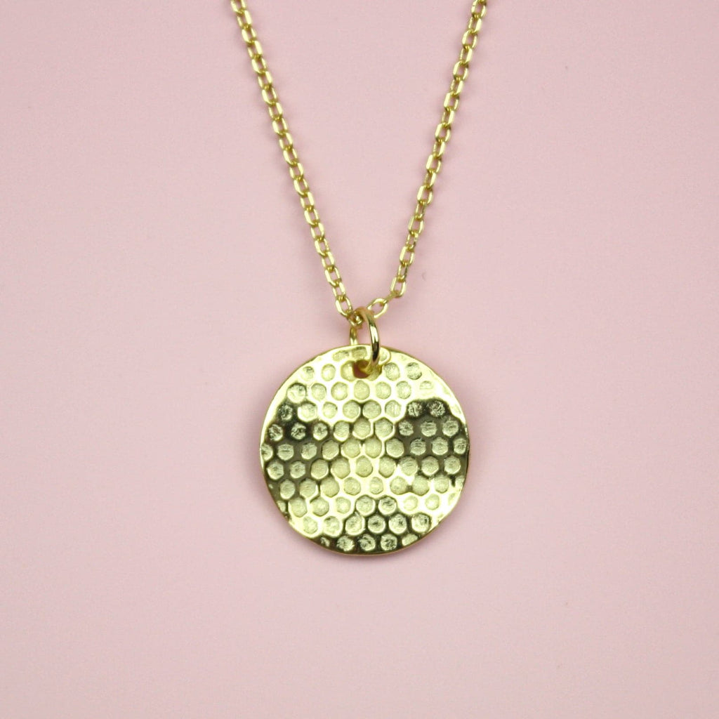 Gold plated stainless steel necklace featuring a gold disk honeycomb pendant