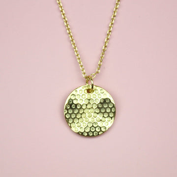 Gold plated stainless steel necklace featuring a gold disk honeycomb pendant
