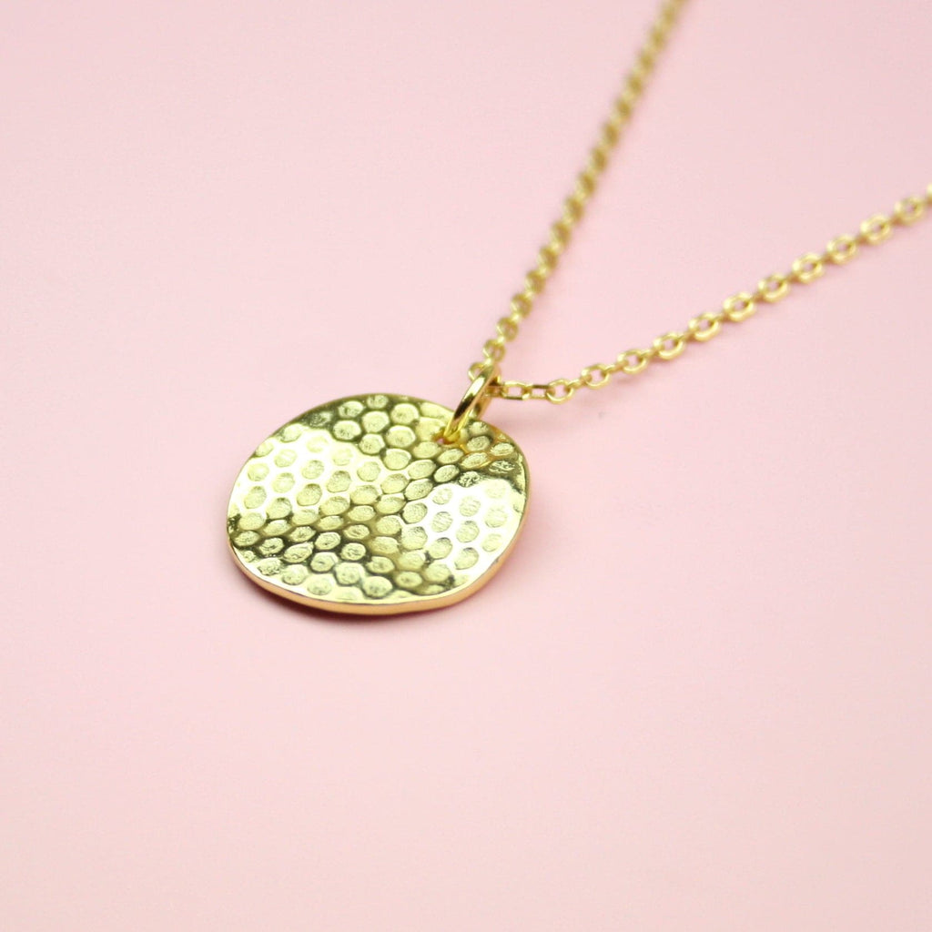 Gold plated stainless steel necklace featuring a gold disk honeycomb pendant