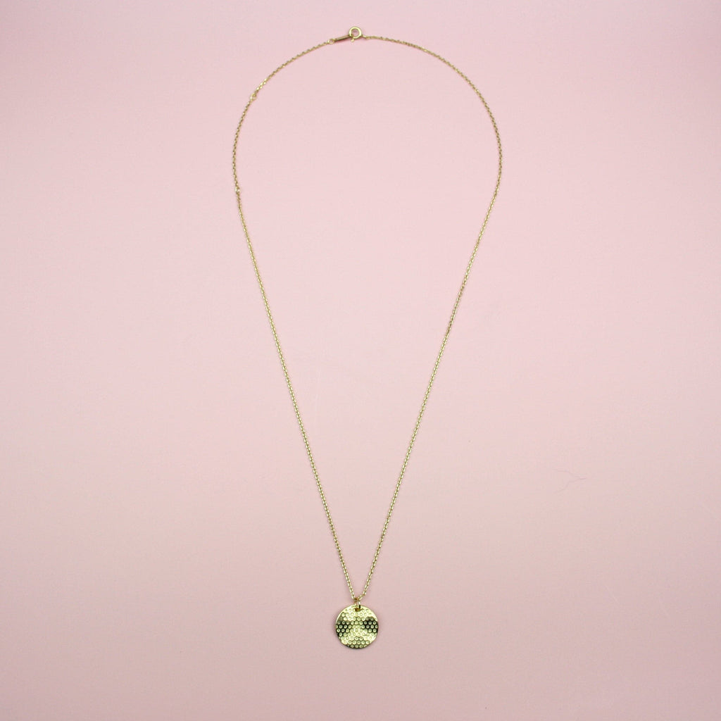 Gold plated stainless steel necklace featuring a gold disk honeycomb pendant