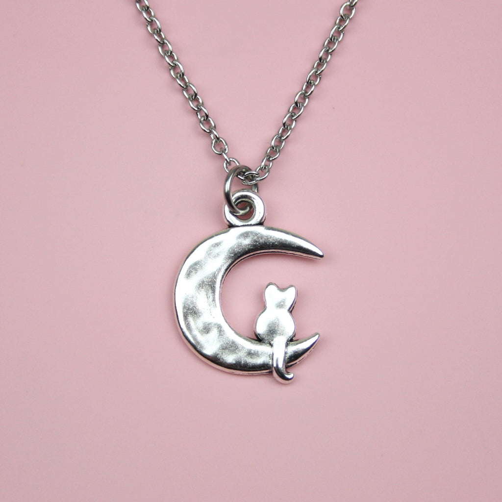 Stainless steel chain featuring a crescent moon pendant with a silhouette of a cat perced at the bottom of the moon