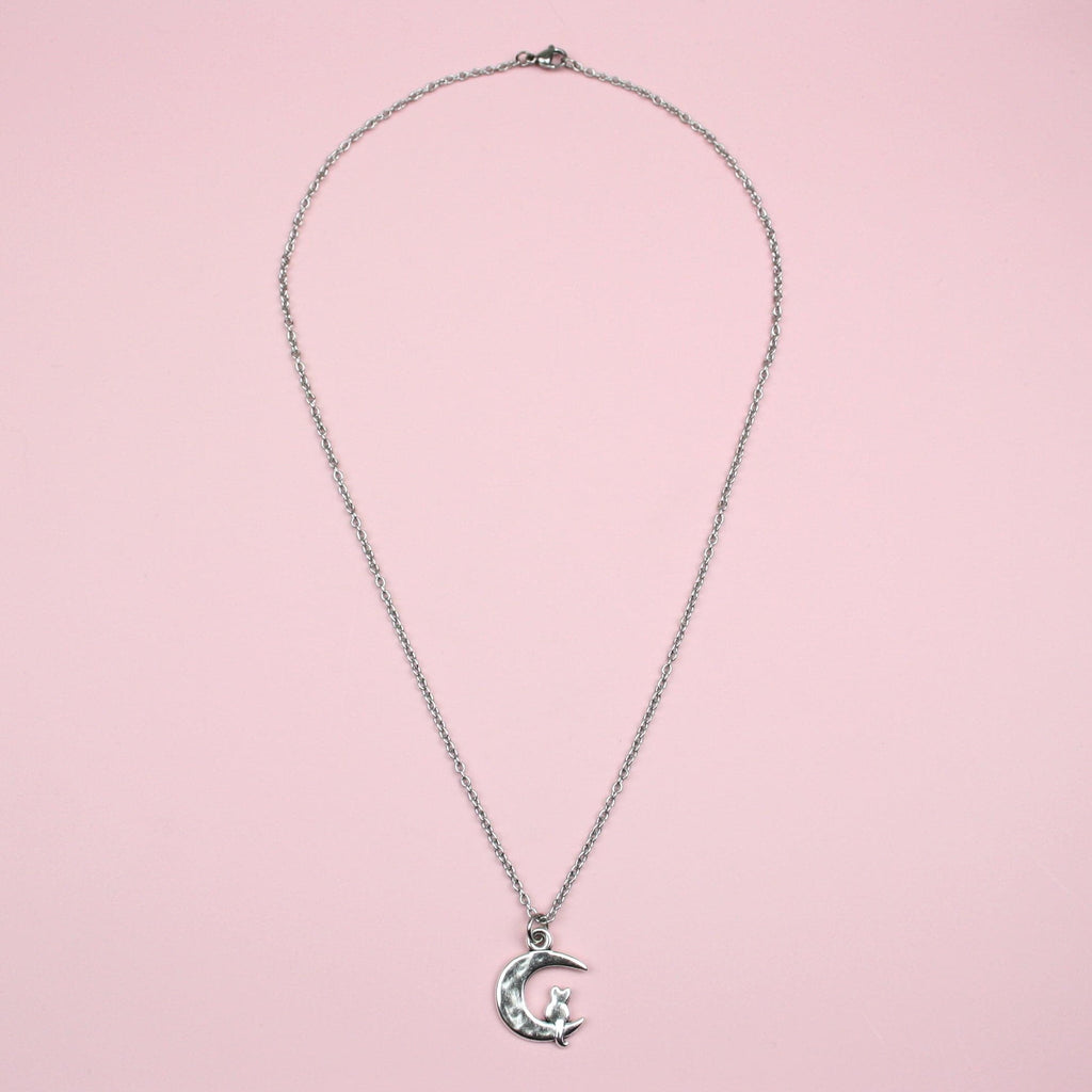 Stainless steel chain featuring a crescent moon pendant with a silhouette of a cat perced at the bottom of the moon