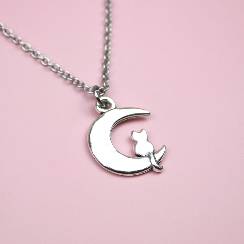 Stainless steel chain featuring a crescent moon pendant with a silhouette of a cat perced at the bottom of the moon