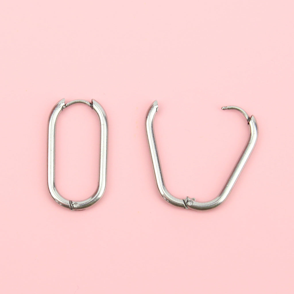 Titanium oval-shaped hoops with a hinge on the top, the right earring is showing what it looks like when opened