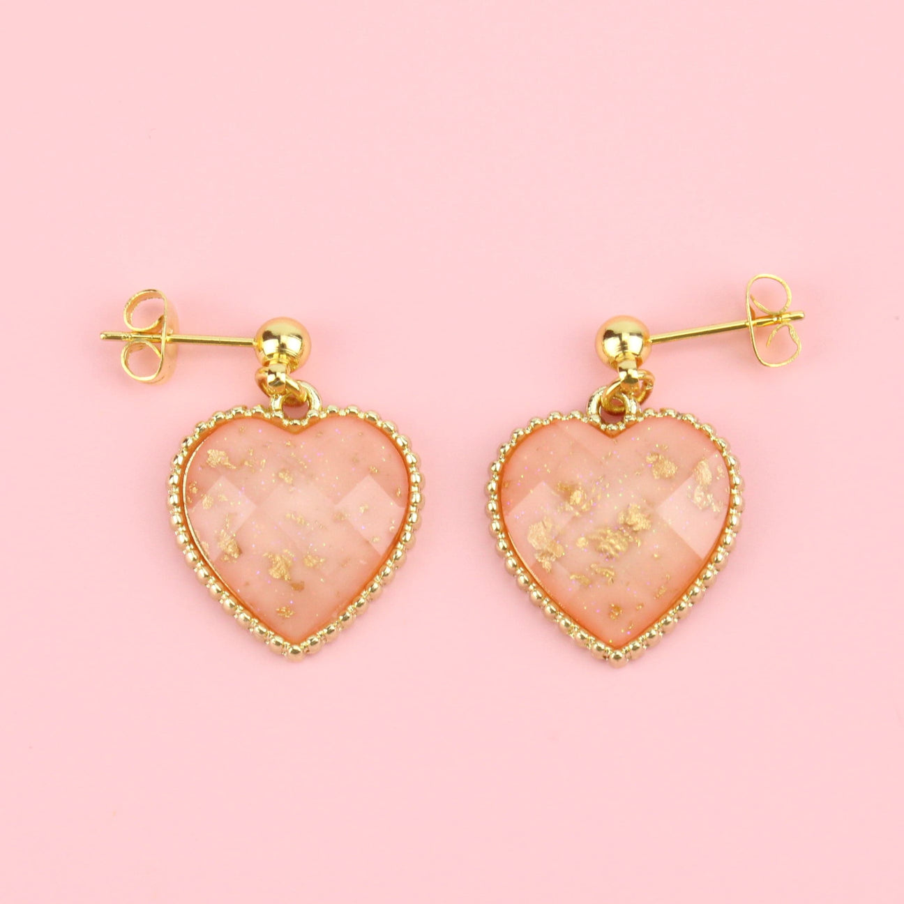 Faceted pink heart charms with gold dust decoration on gold plated stainless steel studs