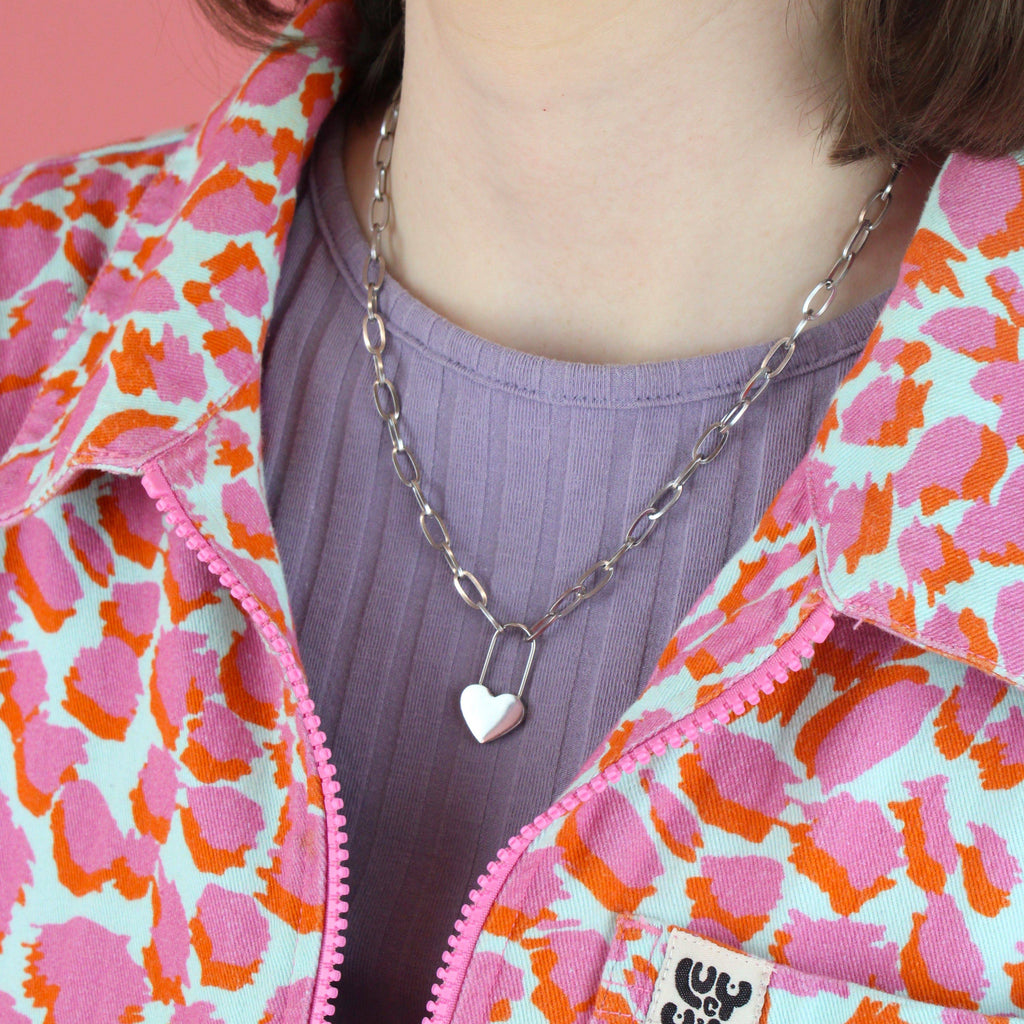 Model wearing oval chain stainless steel necklace with a heart lock charm