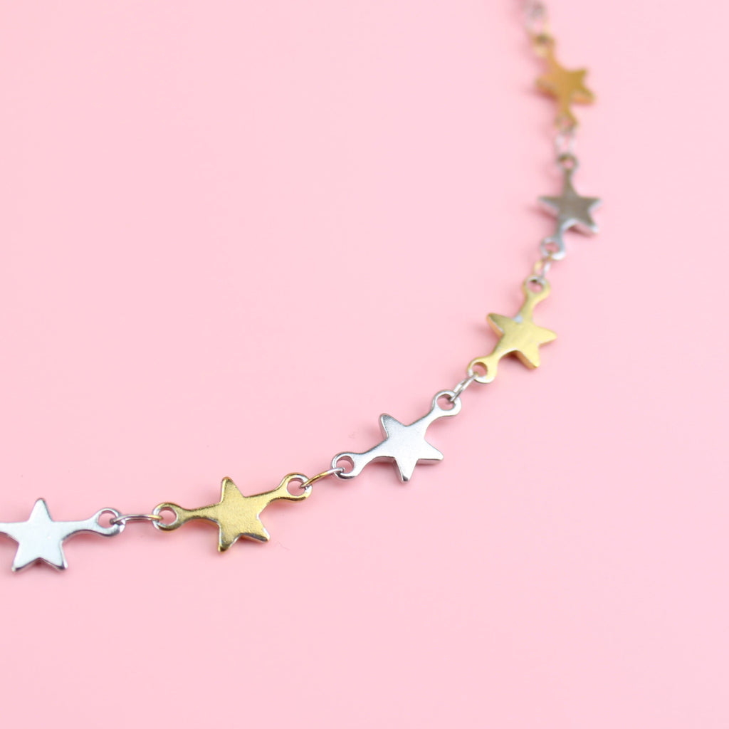Stainless steel necklace featuring silver and gold star charms