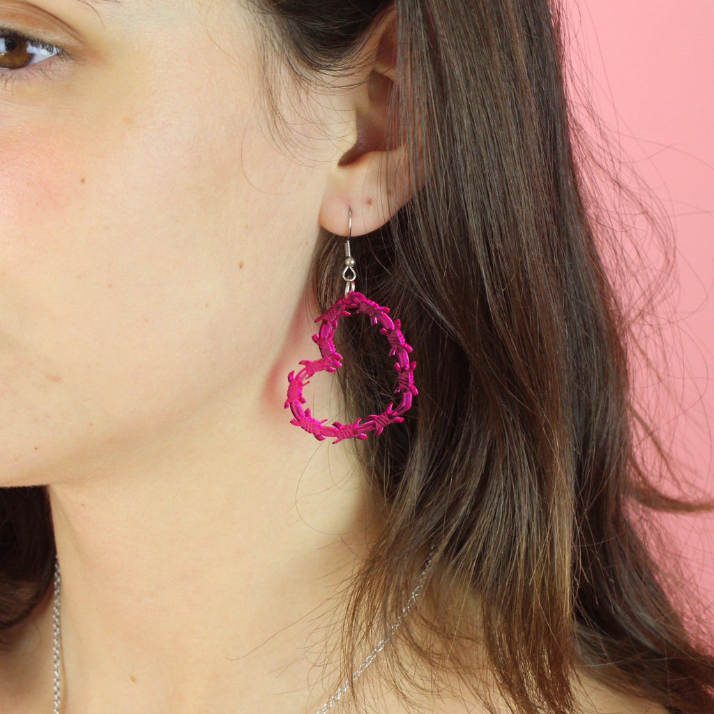 Model wearing Pink barbed WIre Heart Earrings