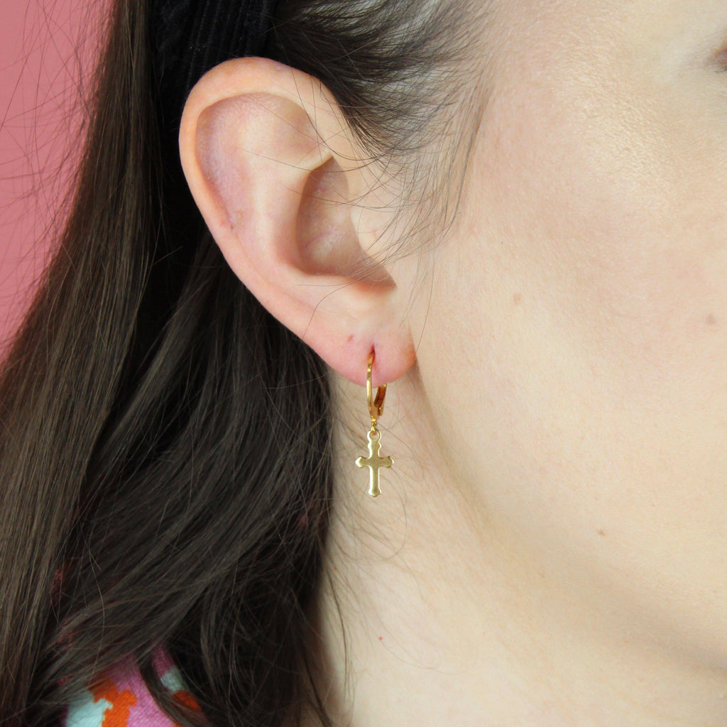 ear wearing gold plated gothic cross charms on huggie hoops