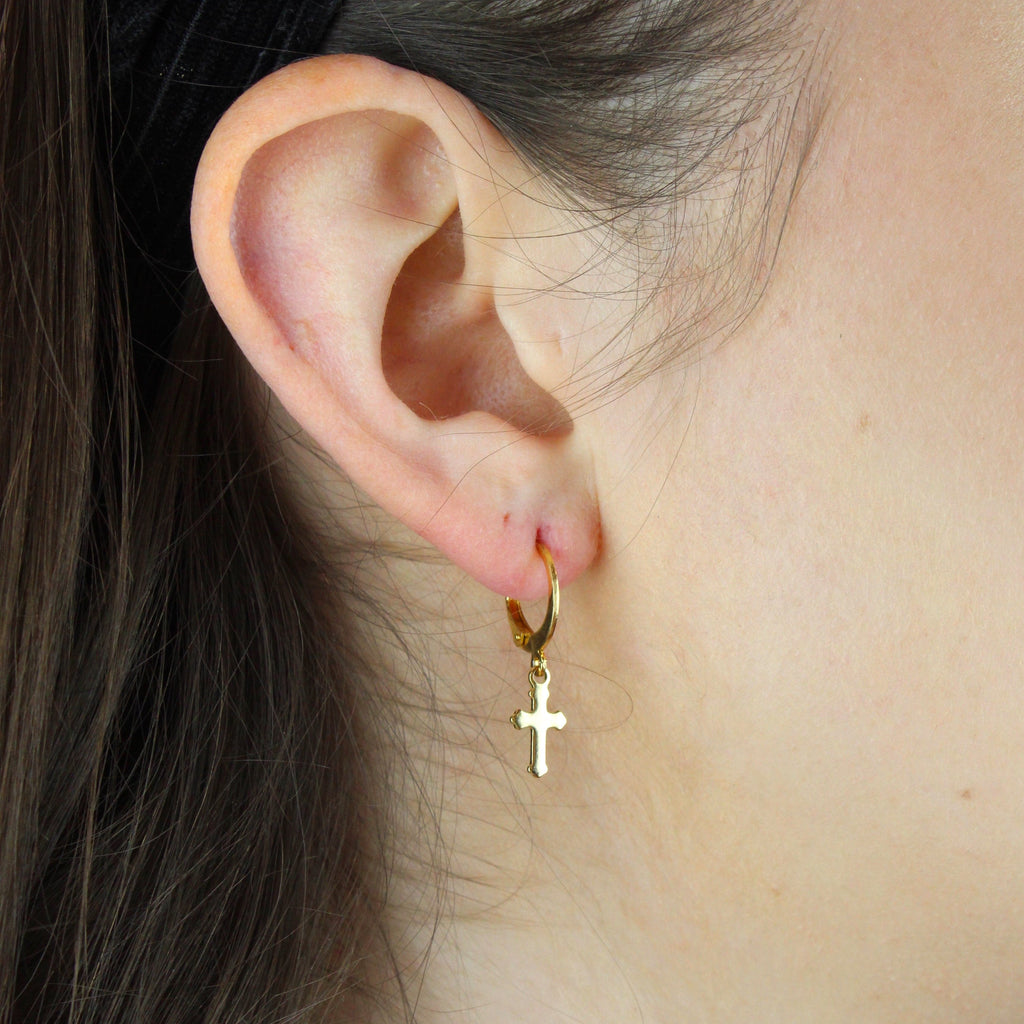 ear wearing gold plated gothic cross charms on huggie hoops