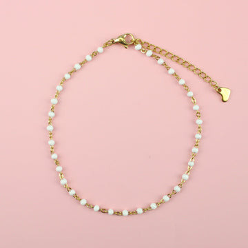 White beaded anklet on a gold plated stainless steel chain