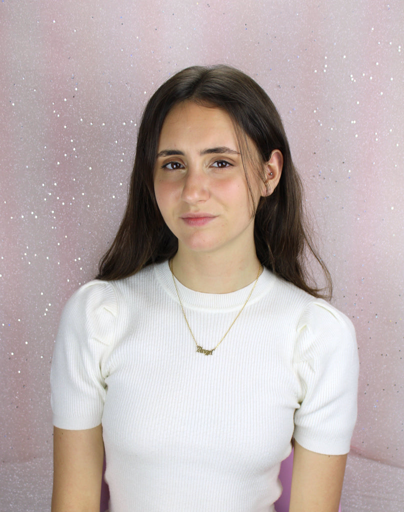 Model wearing Gold plated stainless steel necklace with the word 'angel' written in a gothic font