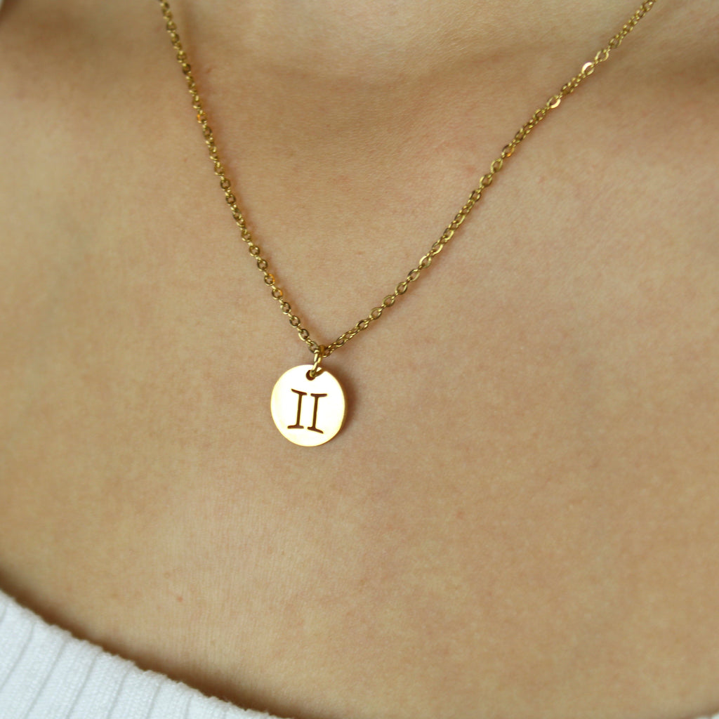 Gold Plated Circle Charm with Cut Out Gemini Symbol on a Gold plated Stainless Steel chain