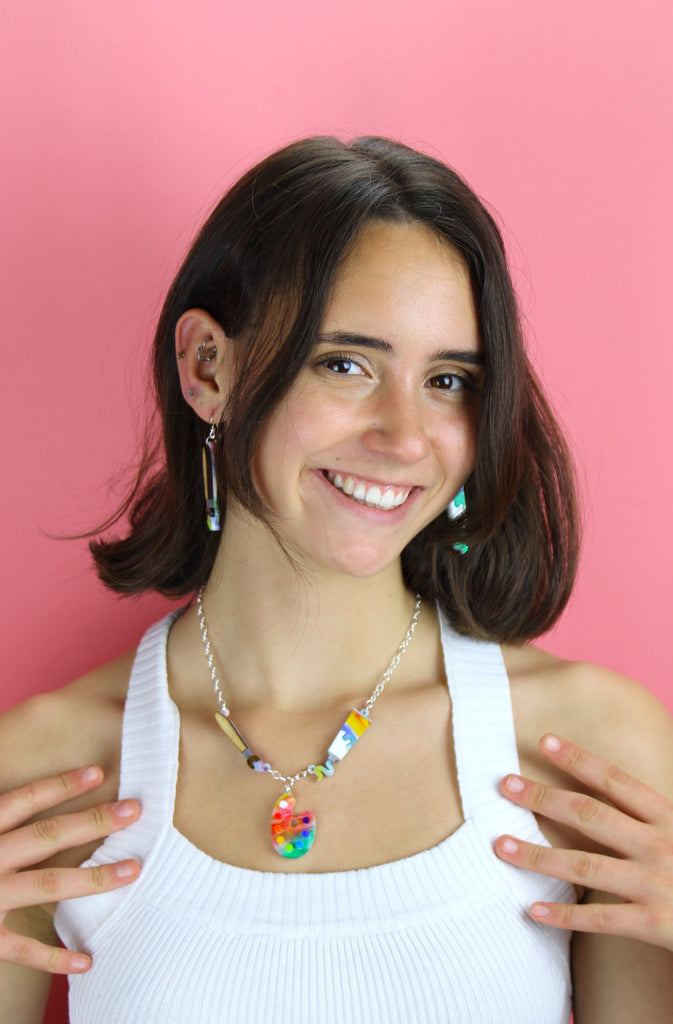 Model wearing both the paint brush earring and the paint tube earring