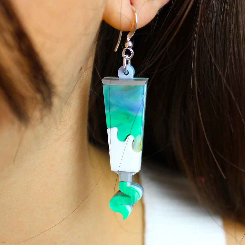 Model wearing paint tube earring