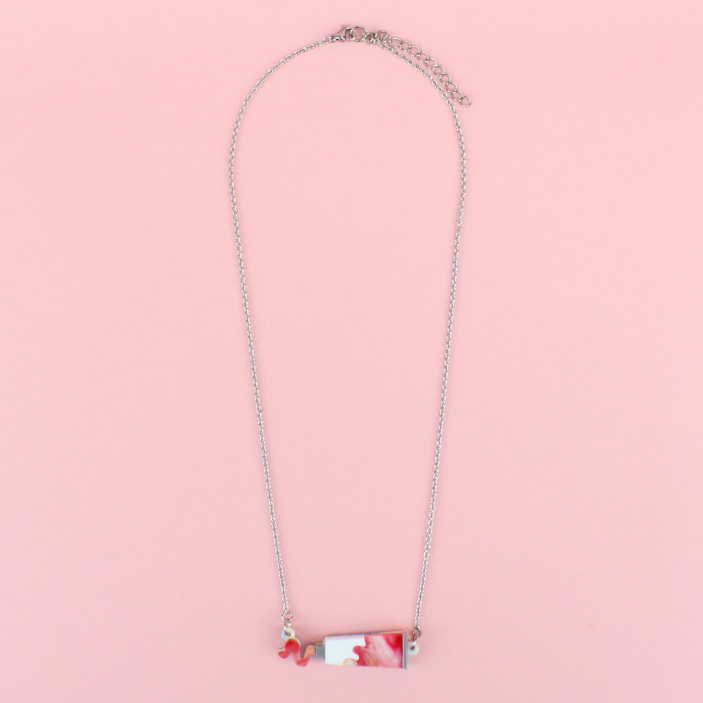 Red marbled acrylic paint tube pendant on stainless steel chain