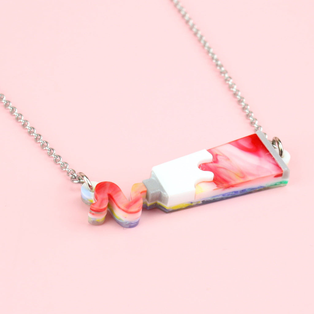 Red marbled acrylic paint tube pendant on stainless steel chain