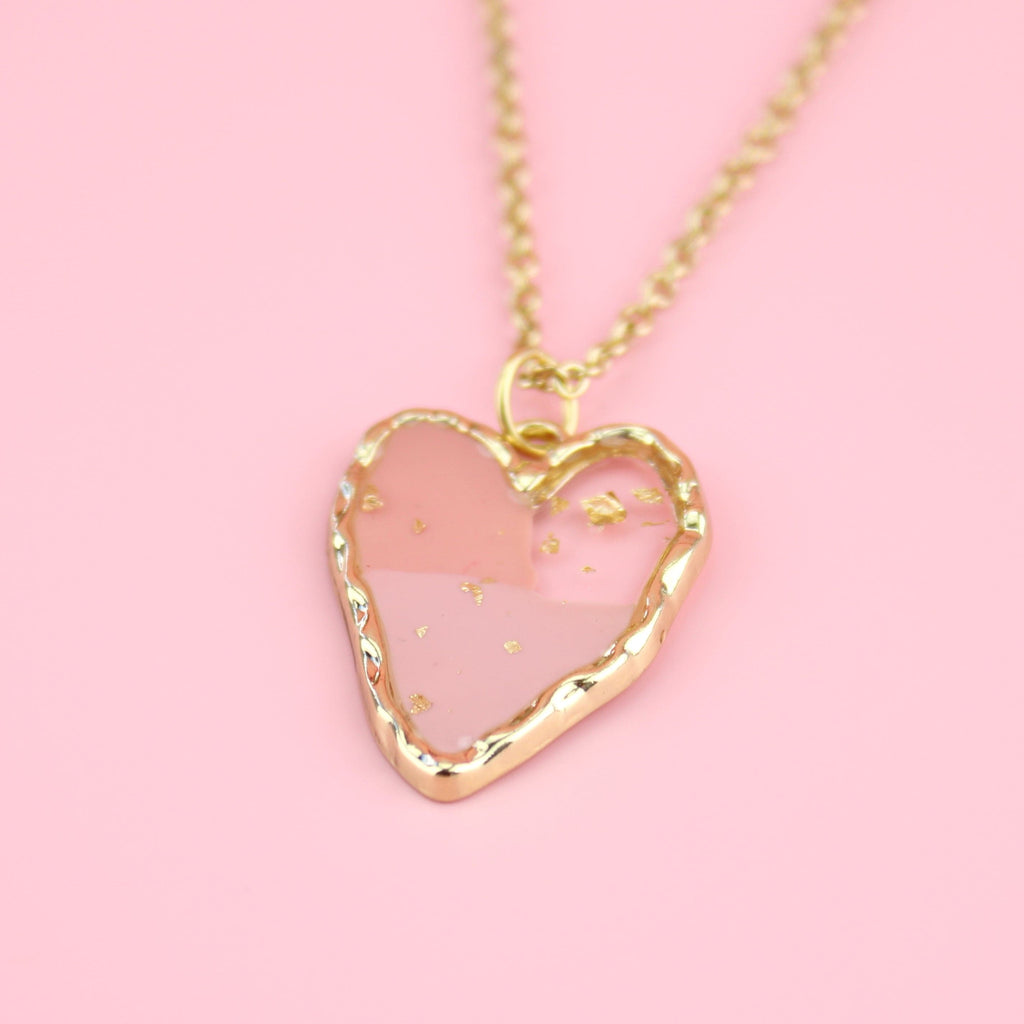 Gold plated stainless steel necklace with a gold heart pendant featuring 2 shades of pink in the middle and gold speck