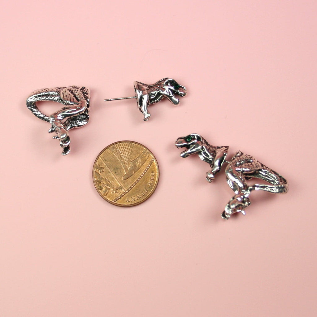 Silver 2 Piece T-Rex Stud Earrings with a penny to measure size