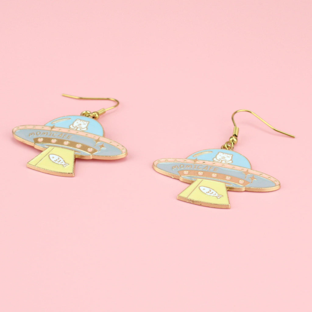 Gold plated UFO design charms on gold plated stainless steel earwires featuring hints of yellow, blue, pink and white 