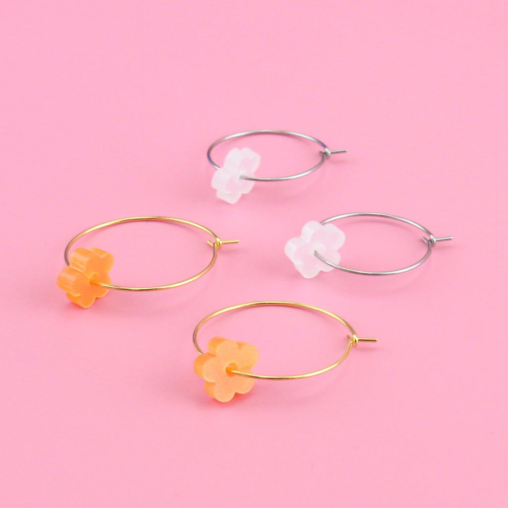 Orange flower charms on gold hoop and white flower charms on silver hoops