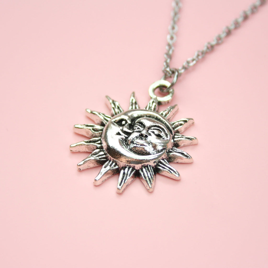 Moon and sun faces with a sun outline on a stainless steel chain