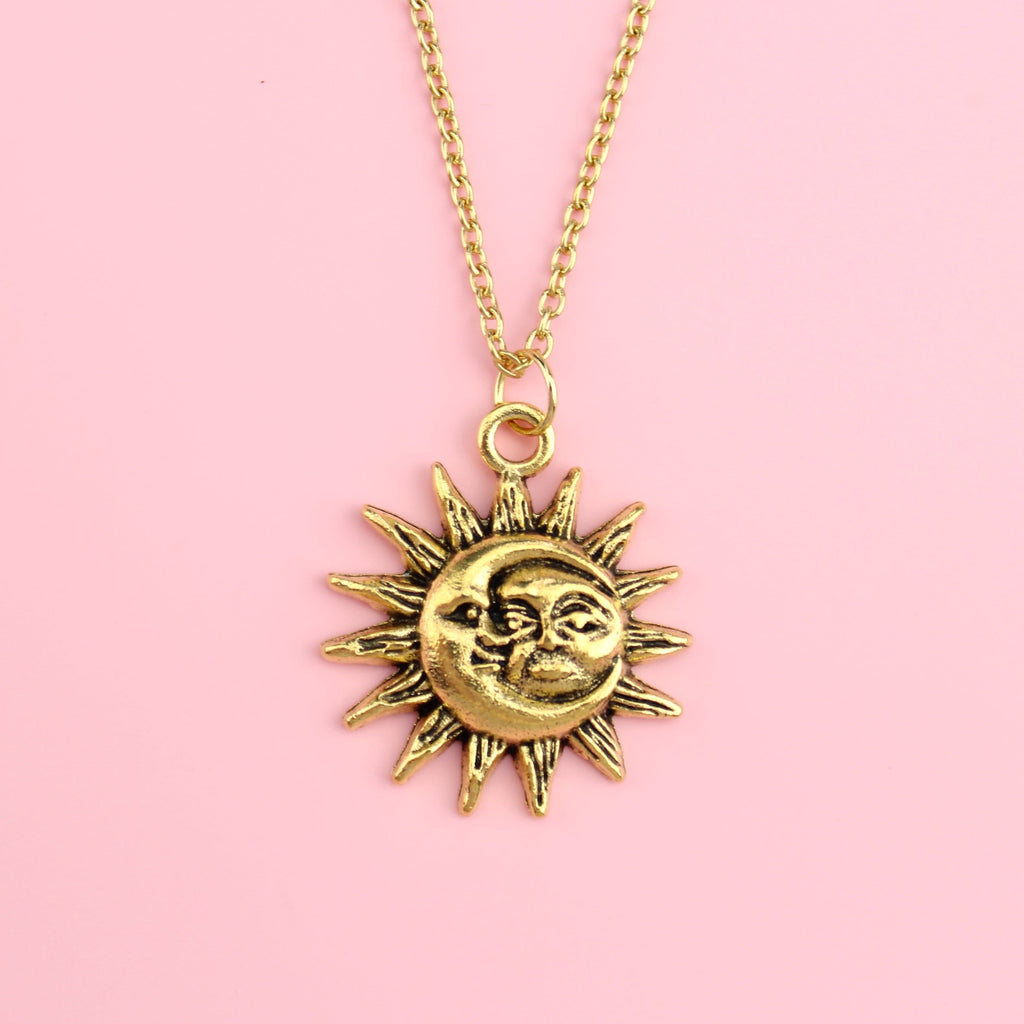 Gold moon and sun face with sun outline on a gold plated stainless steel chain