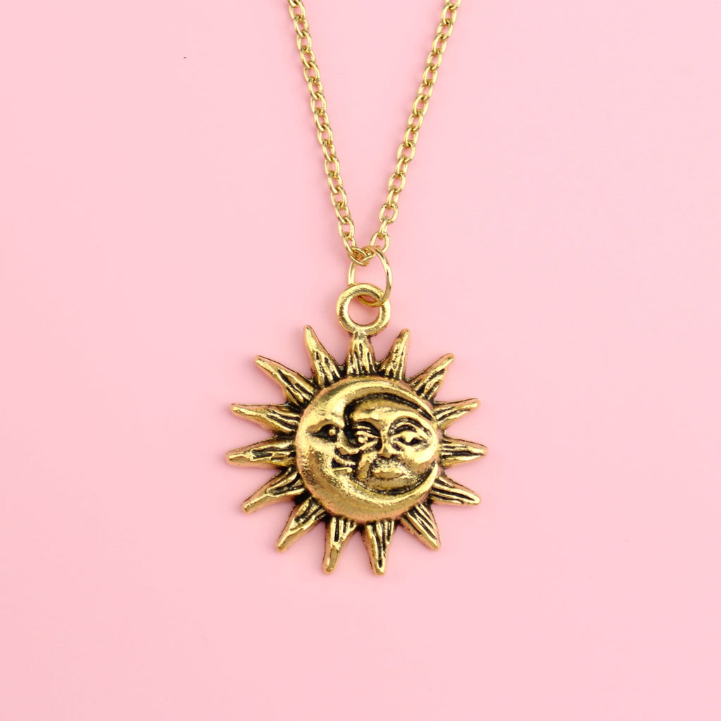 Gold moon and sun face with sun outline on a gold plated stainless steel chain