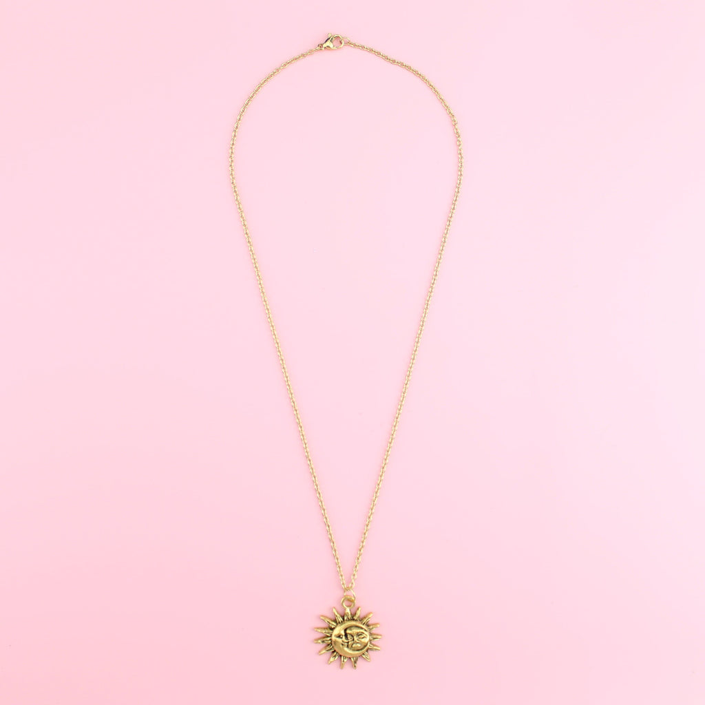 Gold moon and sun face with sun outline on a gold plated stainless steel chain