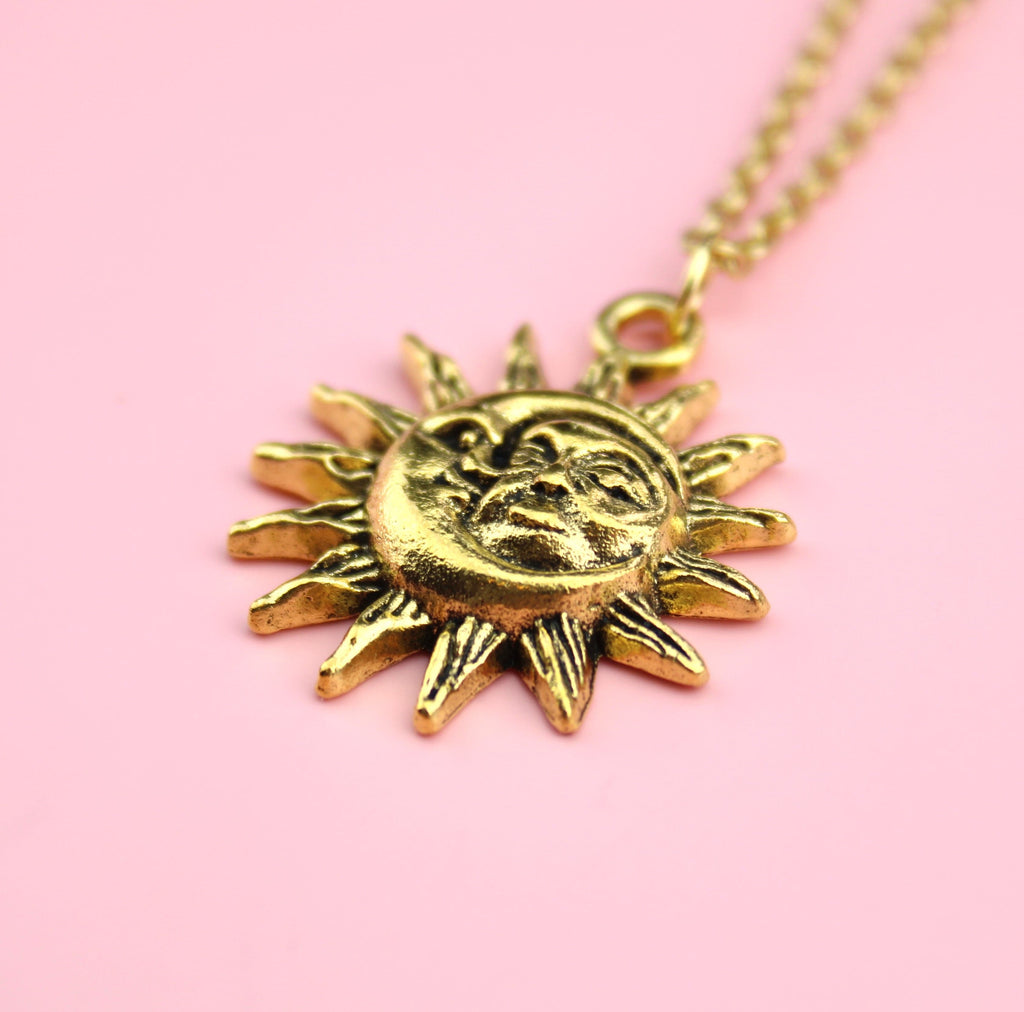 Gold moon and sun face with sun outline on a gold plated stainless steel chain