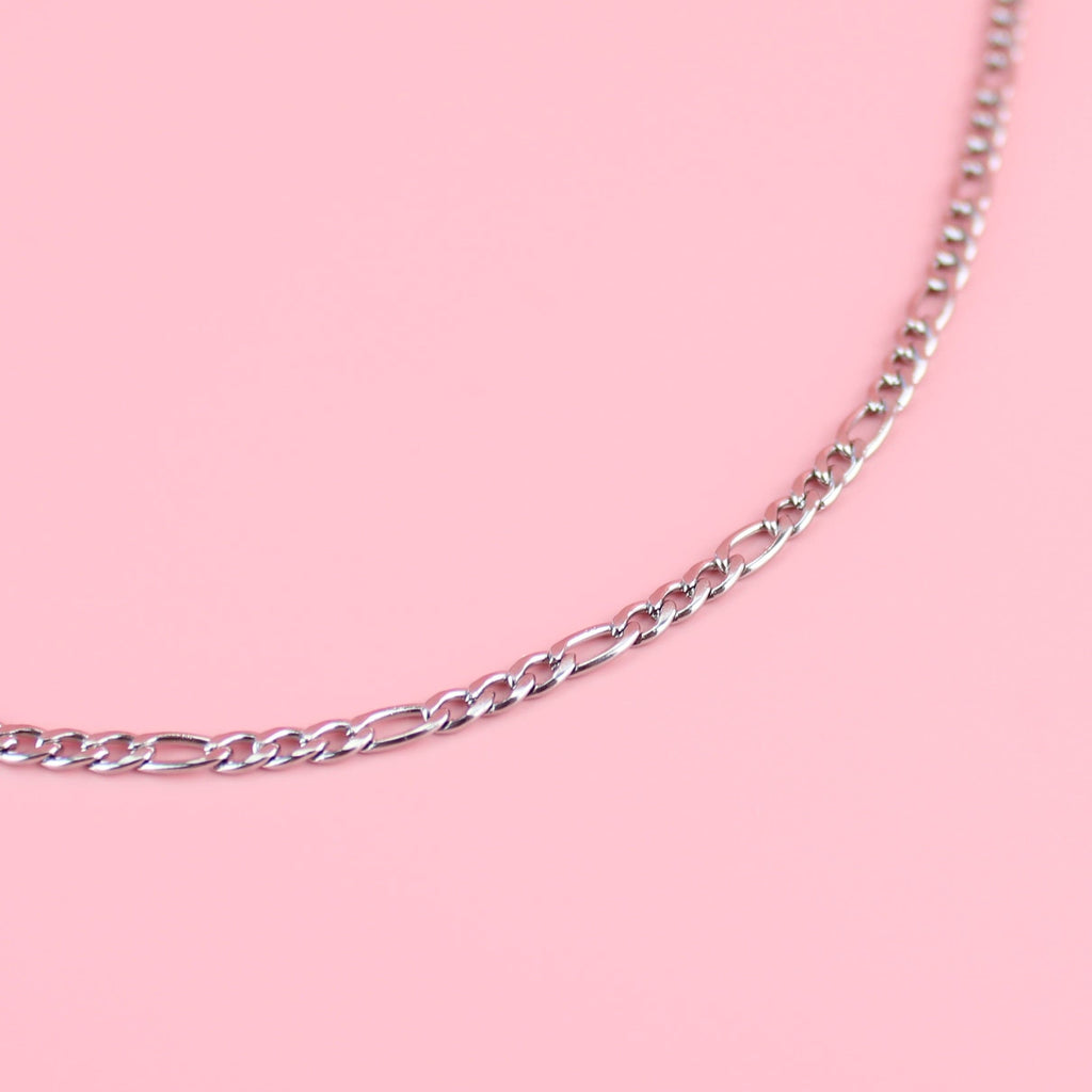20 inch stainless steel figaro necklace features a pattern of three short links followed by one long link