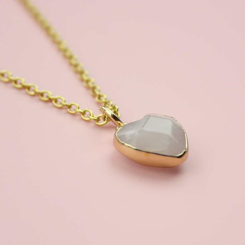 Rose quartz heart pendant with a gold outline on a gold plated stainless steel chain