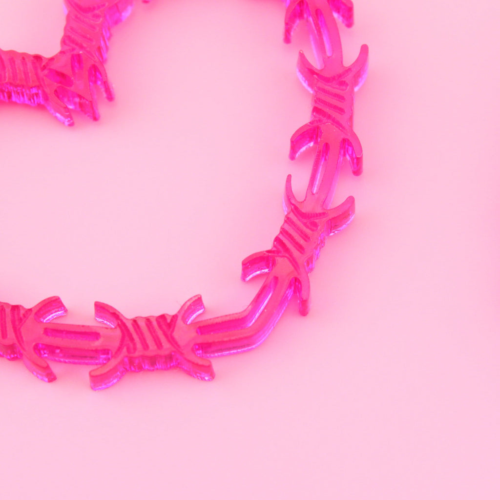 Close up of pink barbed wire pendant