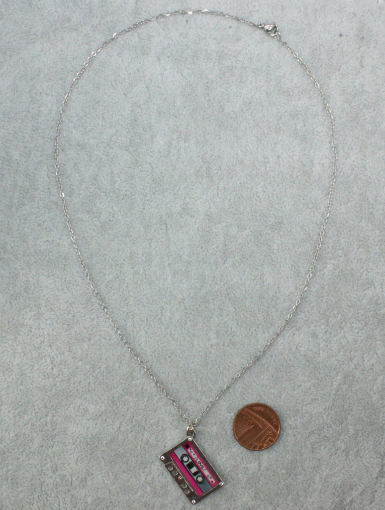 Stainess steel chain with a pendant featuring a mix tape titled the word 'love' surrounded by hearts, the top and bottom of the mix tape is pink. The picture shows a penny next to it for scale