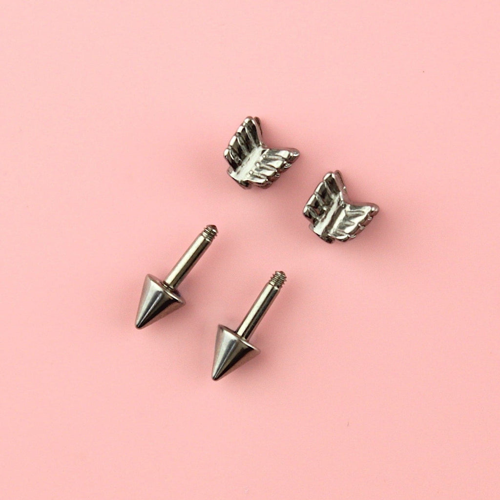 Stainless steel studs in the shape of an arrow showing the front part and the scew-off backs